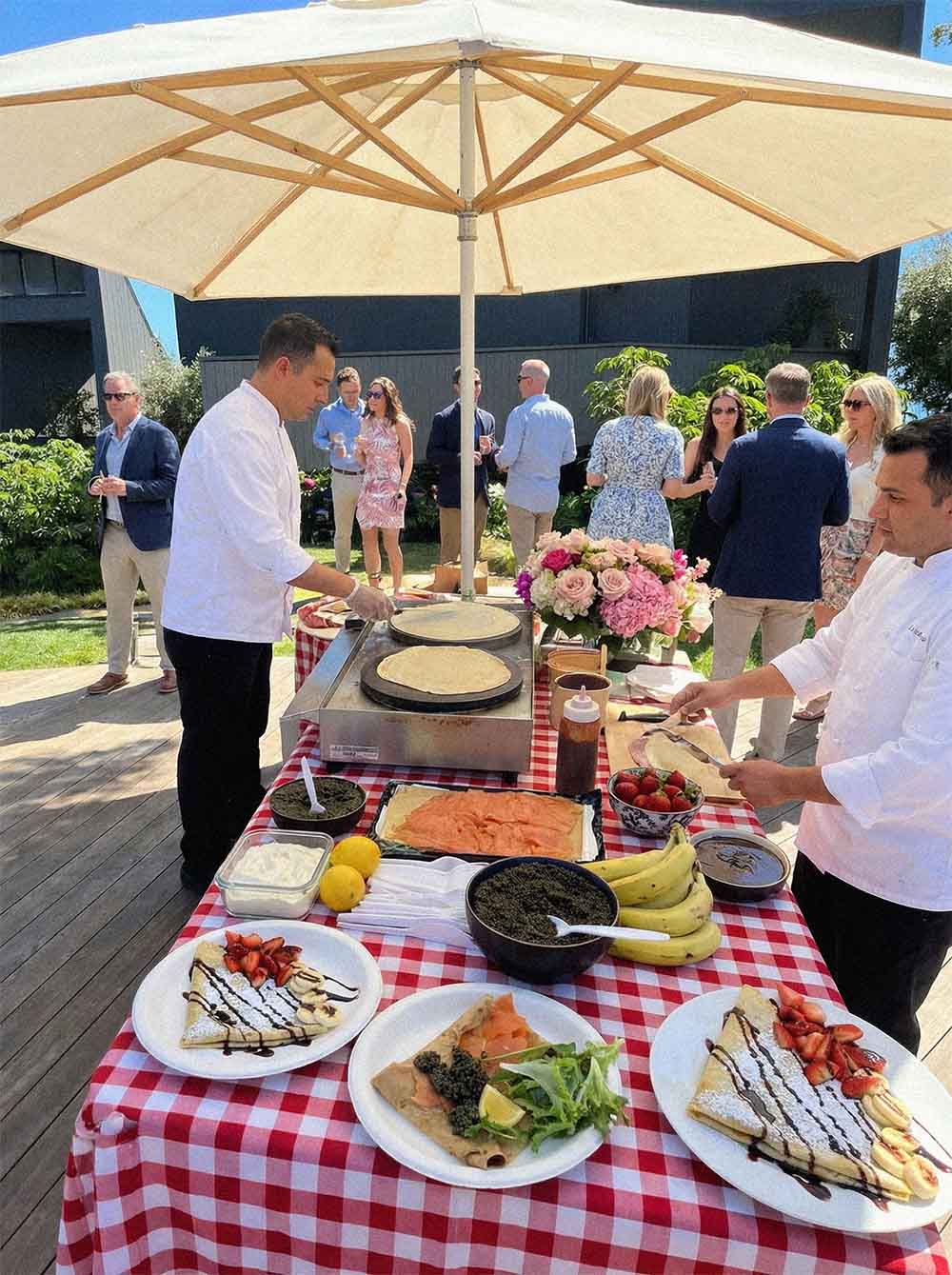 Plated crêpes with salmon, caviar and fresh strawberries at a garden party