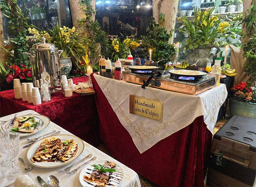 A candlelit Royal French Crêpe station with copper pans and a 'Handmade French Crêpes' sign